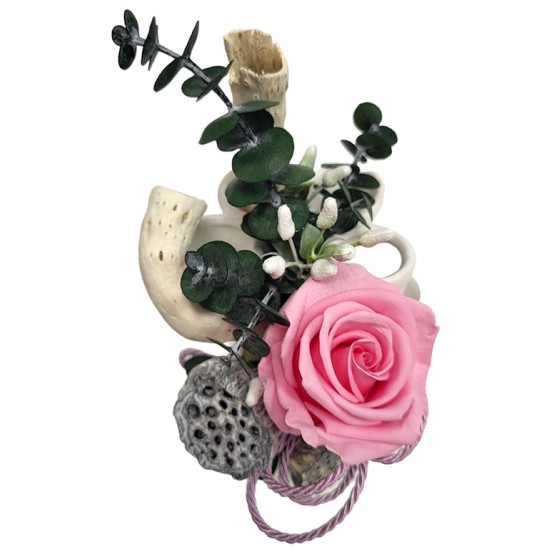 A composition of a sleeping rose in a ceramic vase